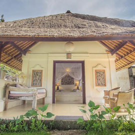 Bali accommodation Terrace patio in front of the traditionally built balinese villa showing a comfortable king size bed inside